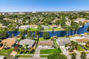 Aerial view of suburban homes along a canal with clear blue skies.
