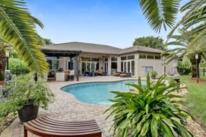 Elegant house with a curved swimming pool and tropical landscaping.