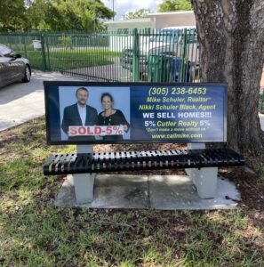 Bench with a political campaign ad featuring two candidates.