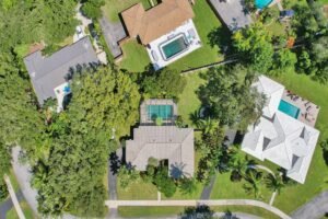 Aerial view of a residential property with a pool and tennis court.