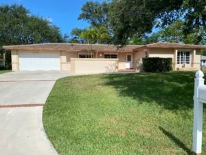 Single-story brick house with curved driveway and green lawn.