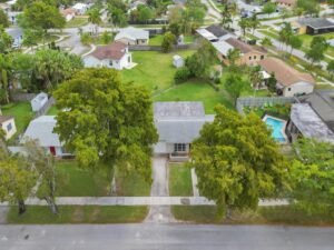 A suburban street with houses and green lawns.