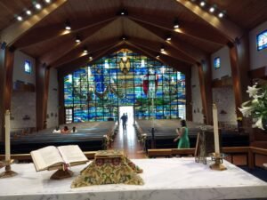 Interior view of a church with stained glass windows and altar.